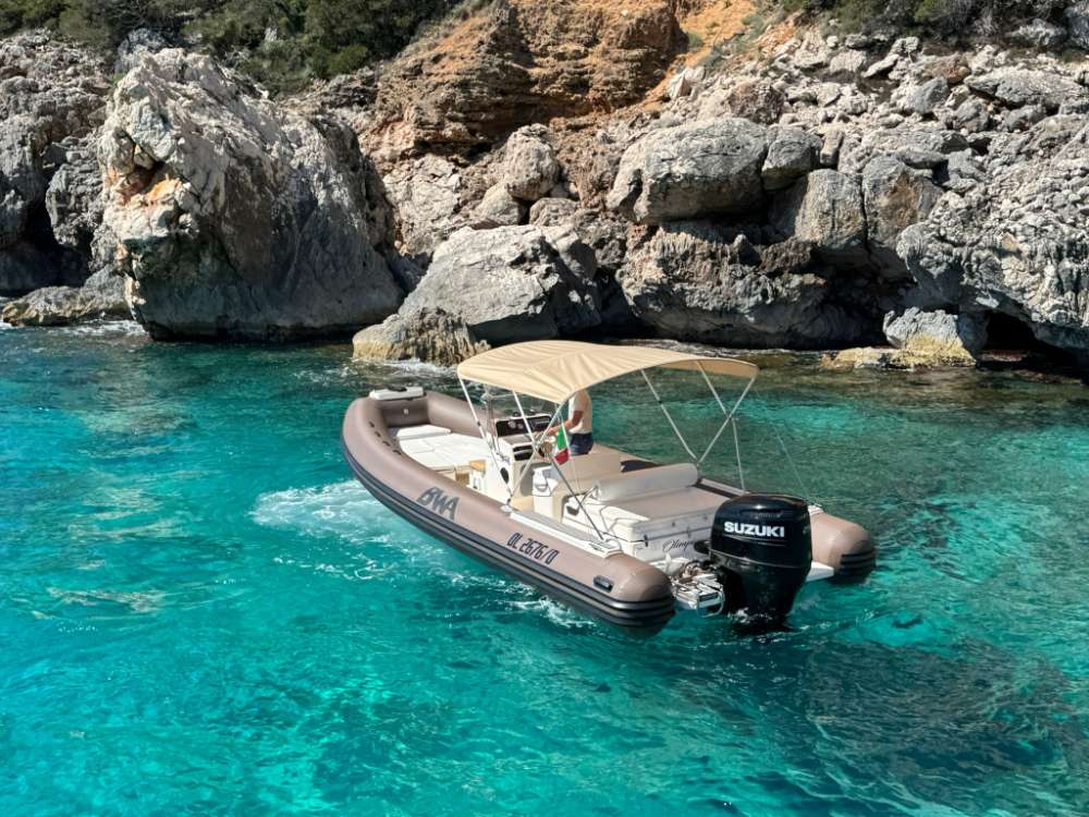Il gommone in una cala rocciosa dalle acque turchesi